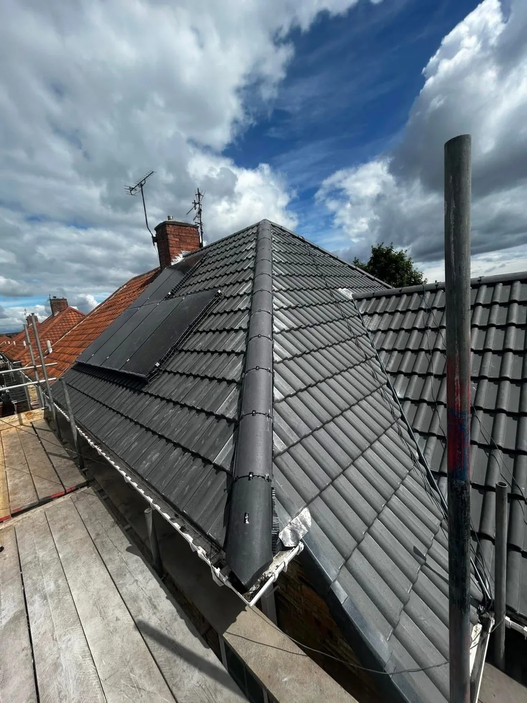 Dark tiled pitched roof with dry ridge detailing