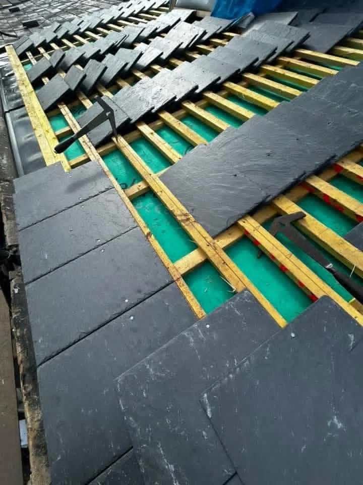Slates being fitted onto timber battens