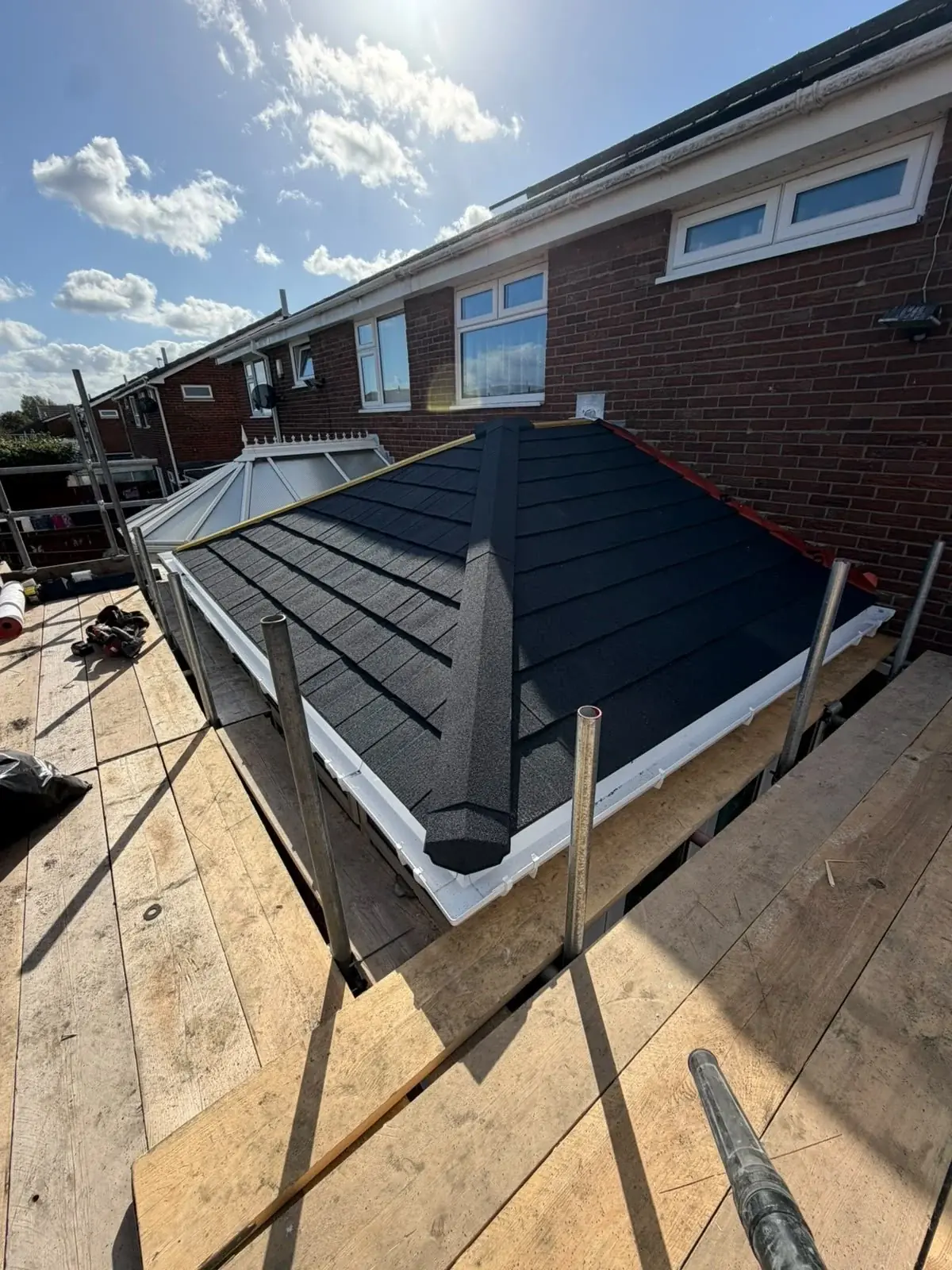 Lightweight tiled conservatory roof conversion adjoining a brick house