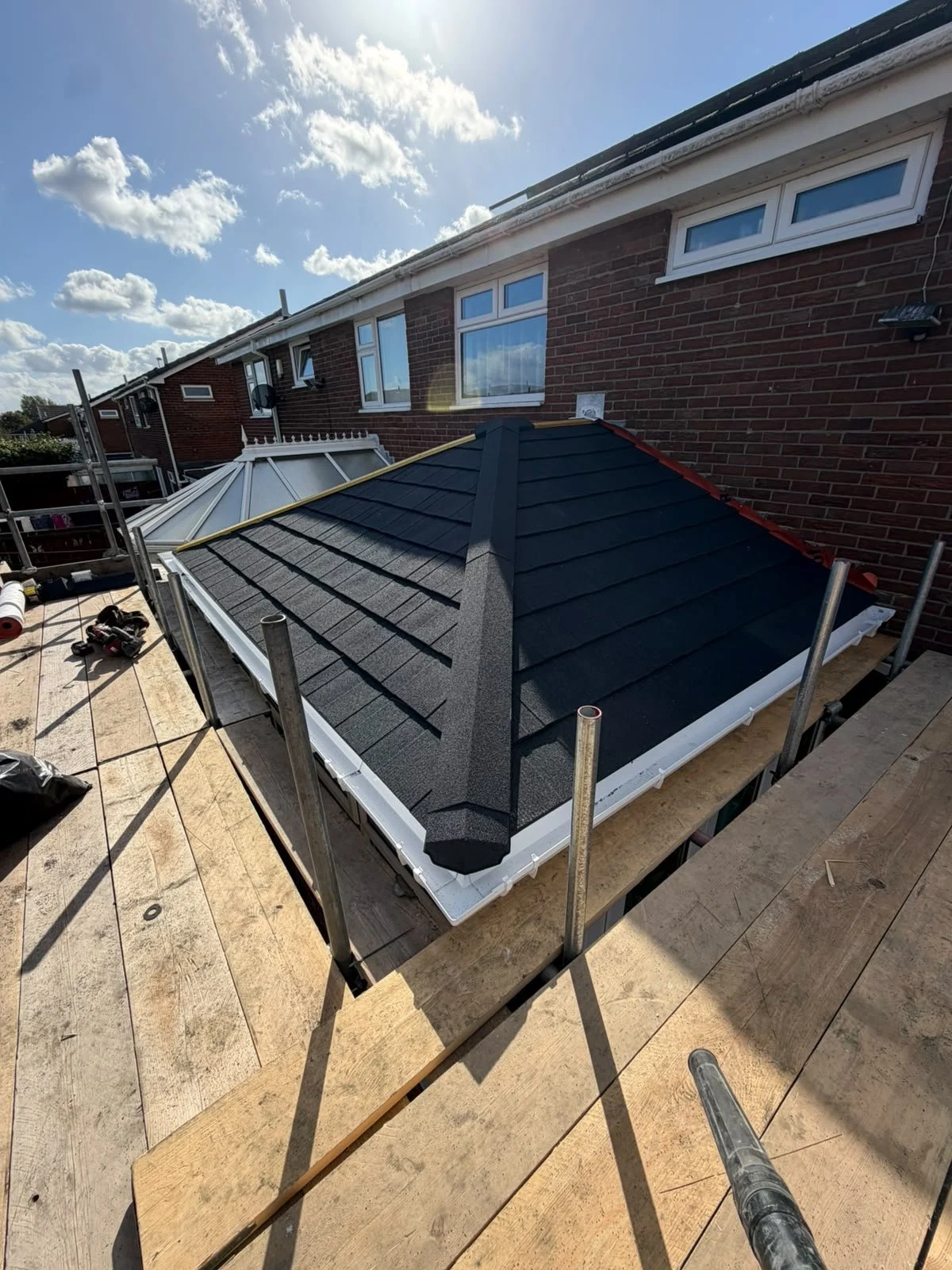 Lightweight tiled conservatory roof conversion adjoining a brick house