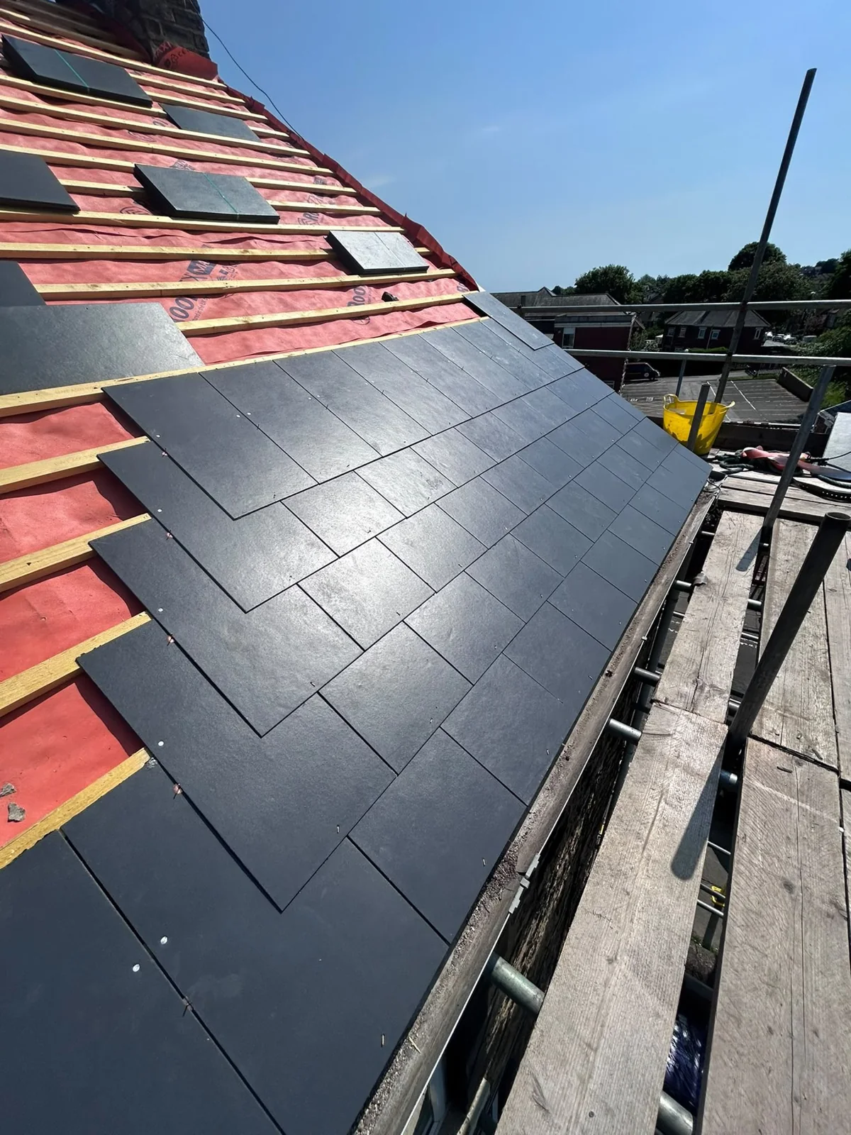 Slate re-roof in progress with timber battens, red membrane and scaffolding