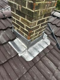 Lead flashing around a brick chimney stack