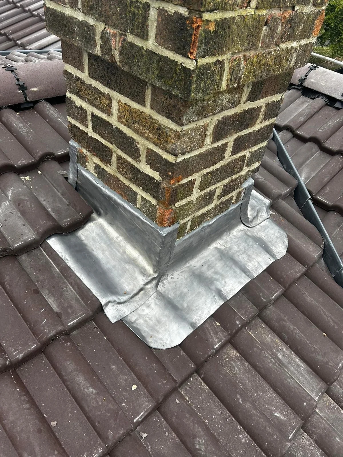 Lead flashing around a brick chimney stack