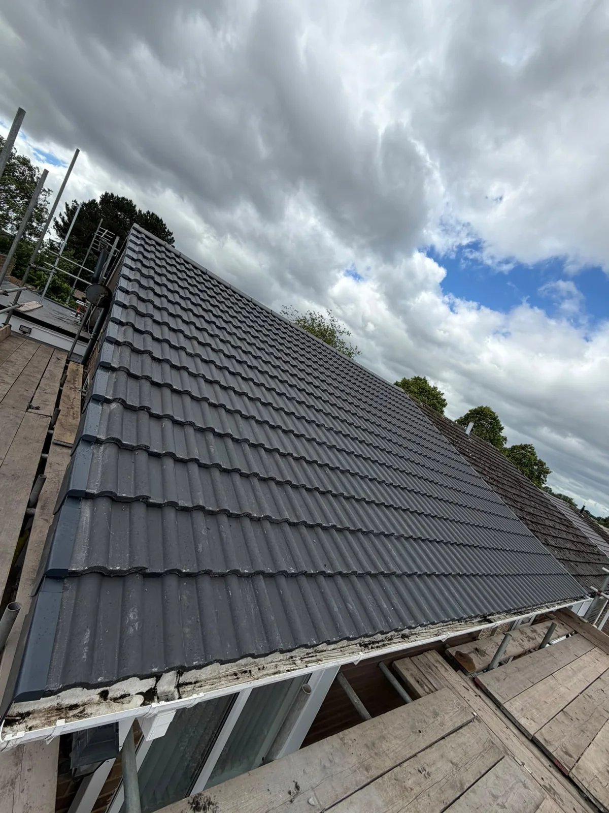 New grey tiled roof with a dry verge at the gable